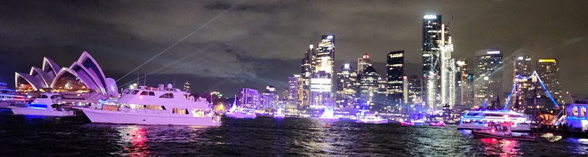 Sydney Harbour at night with city lights reflecting on the water